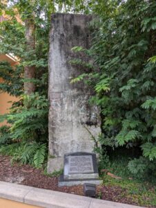 Berlin Wall segment, still faded and with leaves growing around the right side